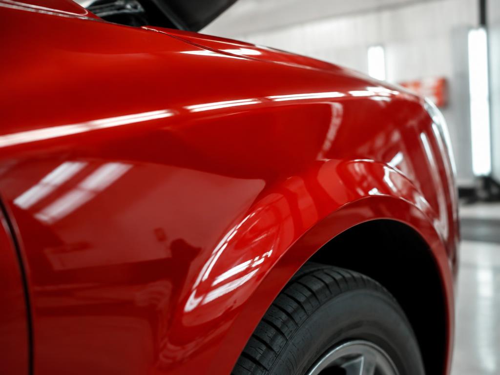 Close-up of a freshly sprayed, glossy red car fender